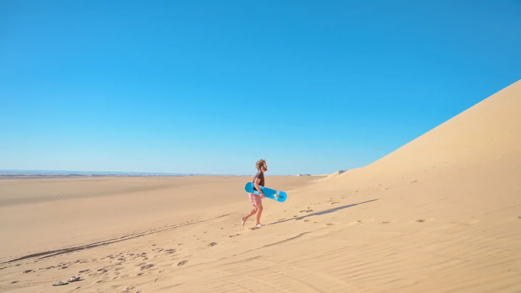 Traveling to the Desert: How, When, and Tips fes desert tour traveler skateboarding in the desert of Merzouga