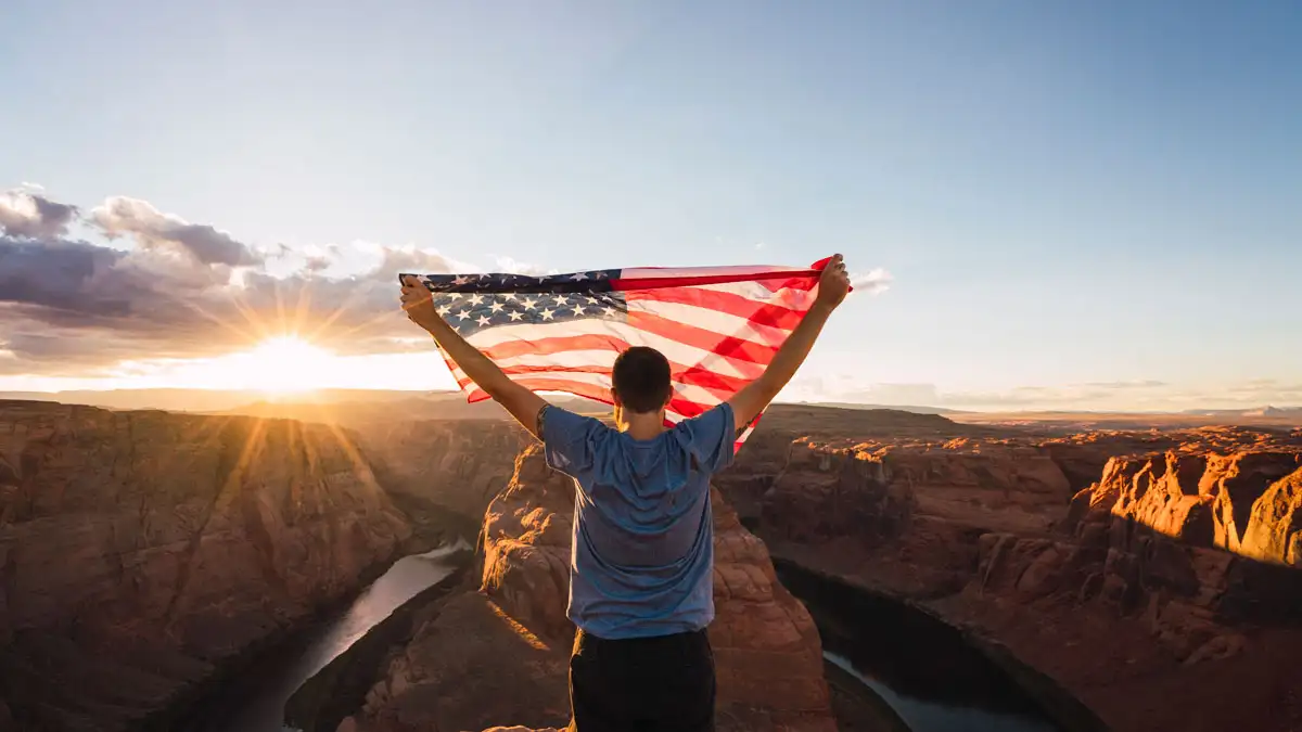 Travel to Morocco from the USA: 411 Guide man holding usa flag in morocco: Travel to Morocco from the USA
