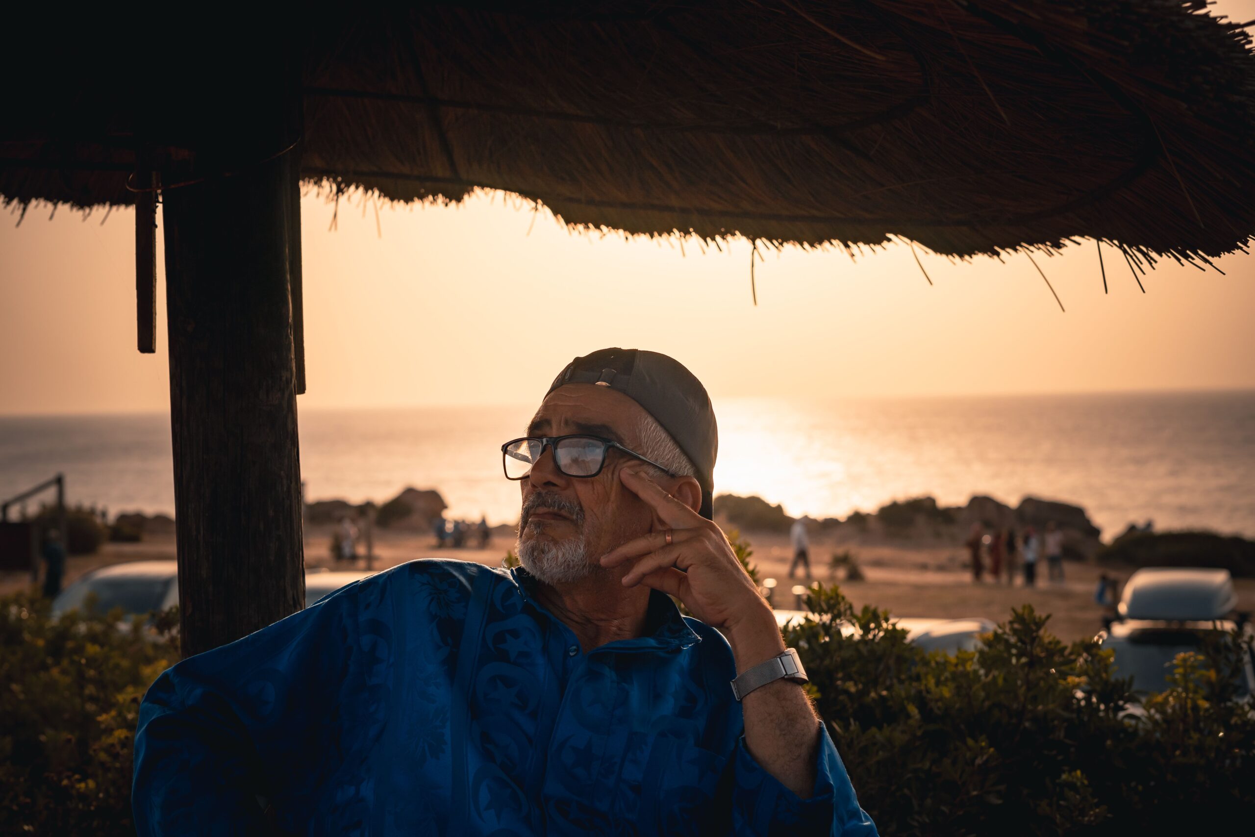 Perfect Day in Casablanca - Beach Day Man sitting under a beach umbrella at sunset in Casablanca; casablanca perfect beach day;