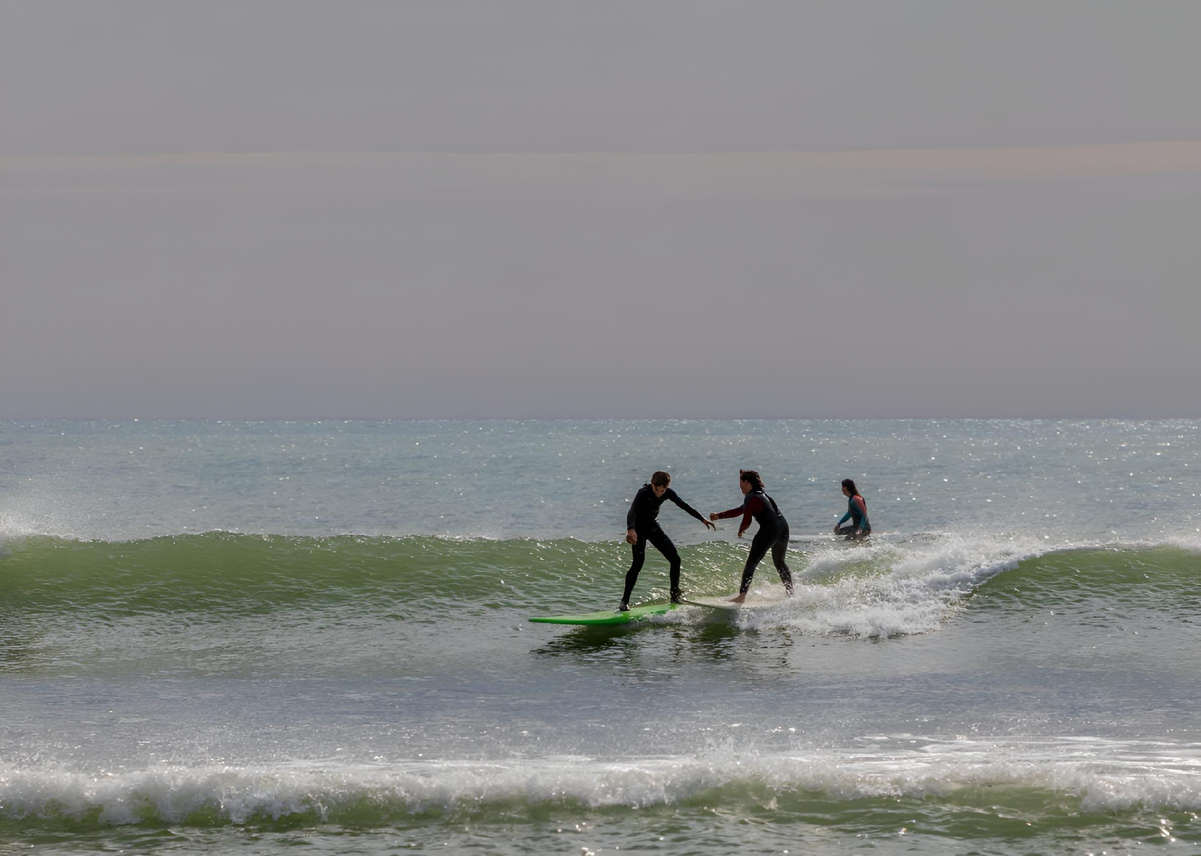 Perfect Day in Casablanca - Beach Day Surfers riding on surfboards on a foamy wave in Casablanca